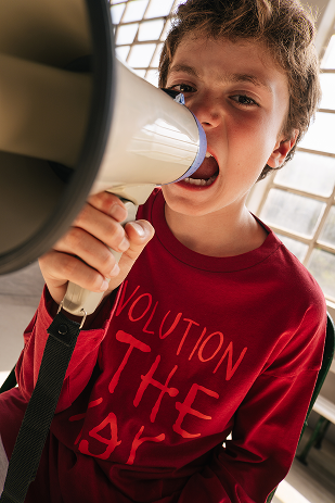 Criança a segurar um megafone, t-shirt vermelha