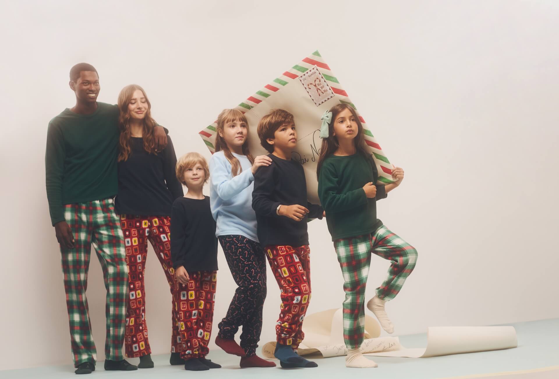Família com pijamas coordenados a posar em estúdio