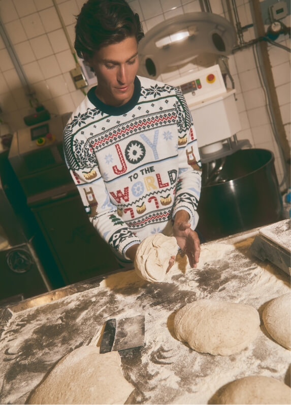 Menino a preparar massa de pão numa bancada de trabalho