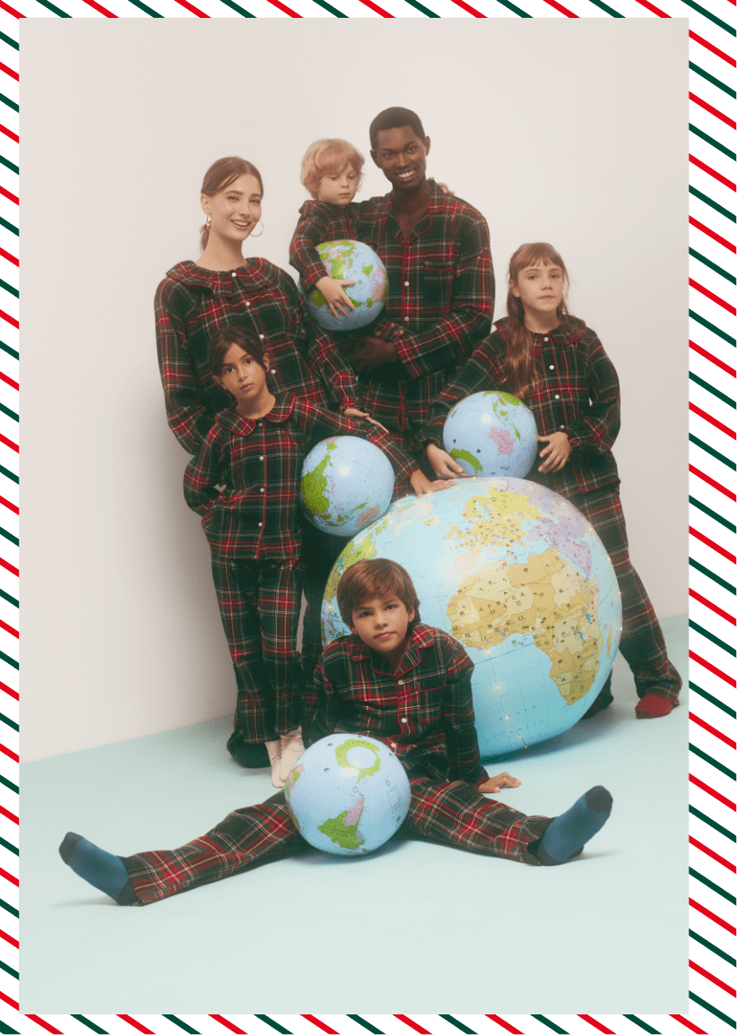 Família com pijamas natalícios em redor de globos