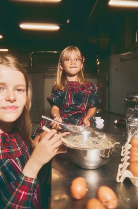 Duas meninas a cozinhar lado a lado, ambiente de cozinha